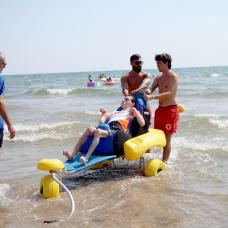 Iván prueba el nuevo sillón ergonómico adaptado durante la presentación del proyecto en la playa de El Cabanyal.