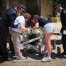 Momento en que dos agentes de la Policía Local de Torrent y dos failiares de las víctimas depositan la corona de flores en el monumento.