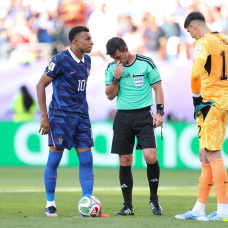 PHILADELPHIA, PENNSYLVANIA - JULY 04: Kylian Mbappe #10 of France checks with Referee Ilgiz Tantashev before placing the ball before a penalty kick while Orlando Gill #12 of Paraguay watches during the FIFA World Cup 2026 Round of 16 match between Paraguay and France at Philadelphia Stadium on July 04, 2026 in Philadelphia, Pennsylvania. (Photo by Dan Mullan/Getty Images)