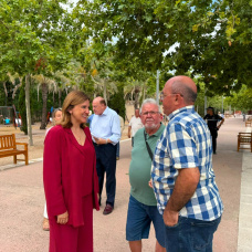 María José Catalá conversa con unos vecinos en un jardín
