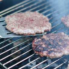 Hamburguesas de carne de vacuno durante su preparación a la parrilla, un formato similar al de la nueva Smash Burger de Mercadona analizada por Healthy Miguel.