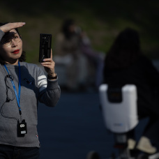 Señora toma una fotografía mientras hace turismo, en las inmediaciones del Museo del Prado.