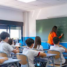 Profesora explica la lección a sus alumnos
