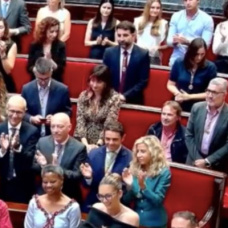 Grezzi sentado mientras todo el hemiciclo aplaude al presidente de Ceuta, Juan Jesús Vivas, cuando la alcaldes, María José Catalá, le ha entregado la Medalla de Honor de la ciudad