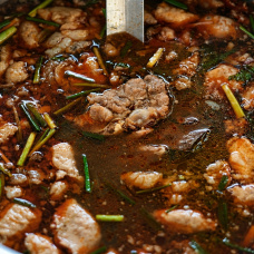 Caldo con carne y hierbas en una olla. Imagen de recurso.
