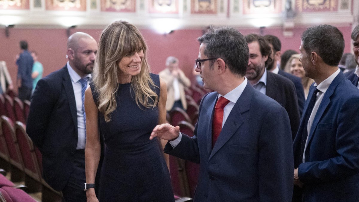 El ministro Félix Bolaños conversa con Begoña Gómez en un acto en Madrid.