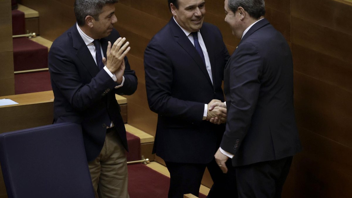 El nuevo presidente de la Generalitat Juanfran Pérez Llorca se da la mano con el portavoz de Vox, José María Llano, tras apoyar su investiruda