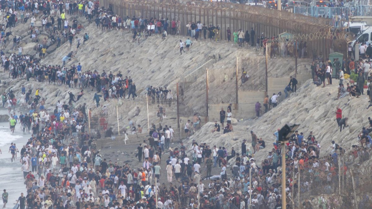 Decenas de migrantes intentan traspasar la frontera entre Ceuta y Marruecos, a 31 de julio de 2026.