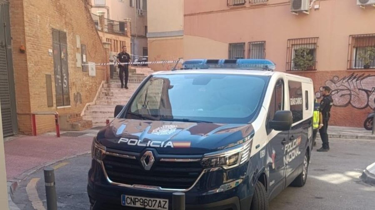 Imagen de un coche de la Policía Nacional en la zona de Málaga donde falleció el joven tiroteado.