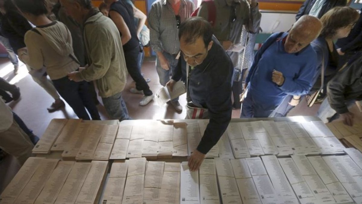 Un ciudadano consulta las papeletas en un colegio electoral