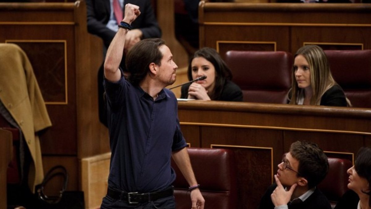 Pablo Iglesias con el brazo en alto saludando al resto de diputados de Podemos en el Congreso de los Diputados.