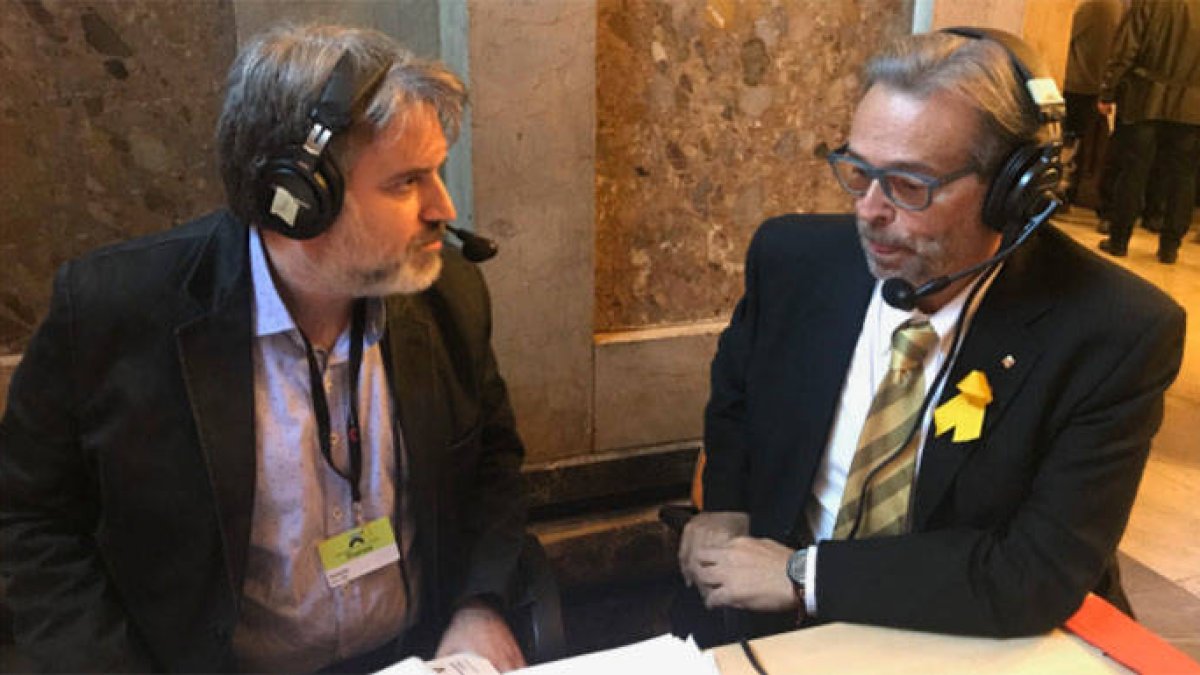 Ernest Benach ataviado con un lazo amarillo de grandes dimensiones en el Parlament.