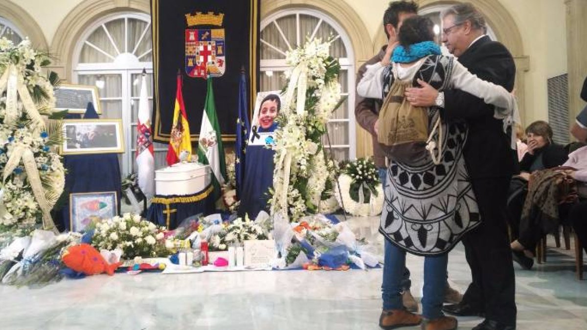 Los padres de Gabriel Cruz abrazan al ministro del Interior en la capilla ardiente de su hijo.
