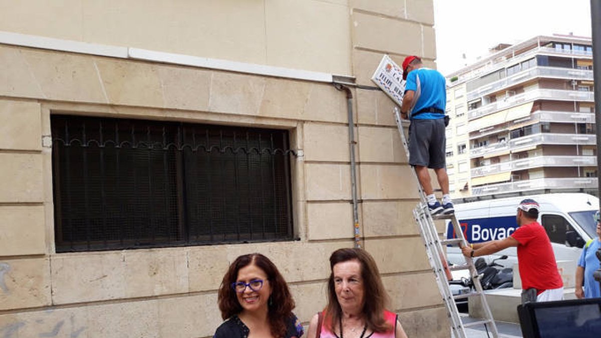 La periodista Pirula Anderius, derecha, sostiene la placa con su nombre.