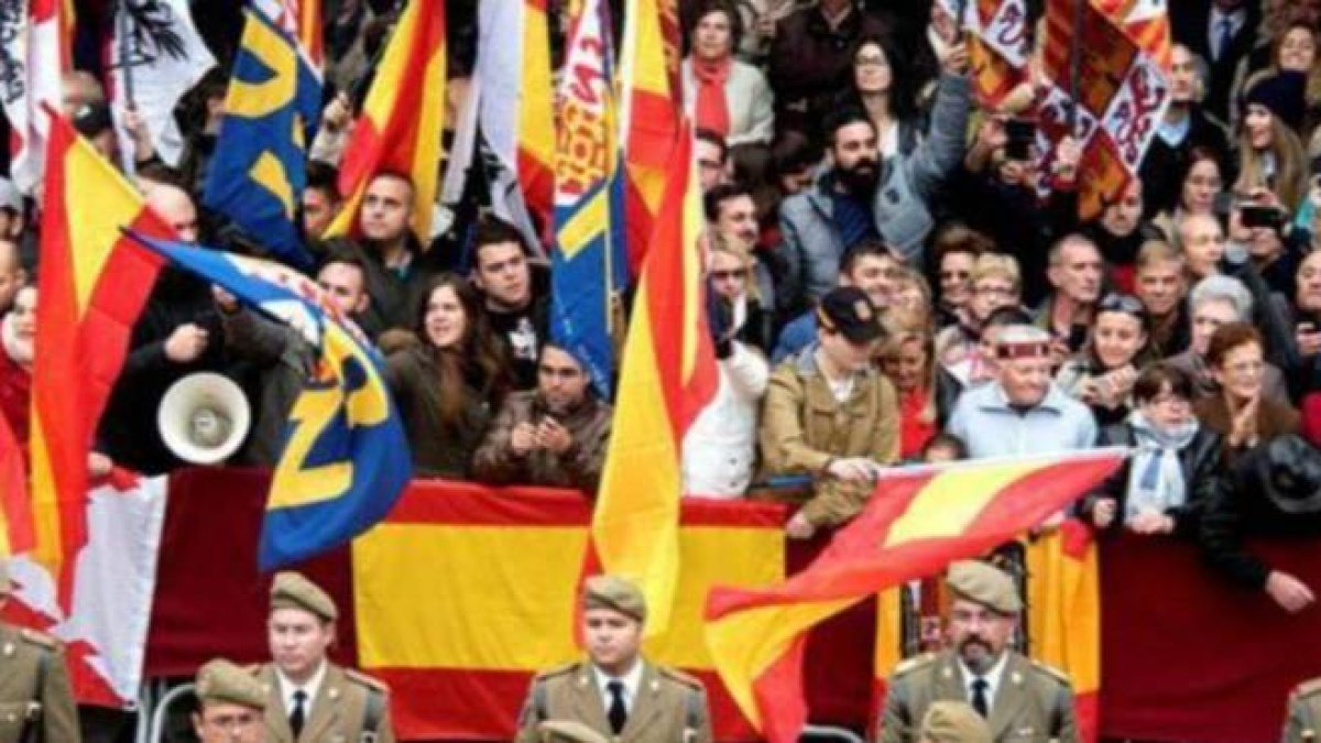 Asistentes a la celebración portando banderas de España, frente a los que exhibian enseñas republicanas y esteladas