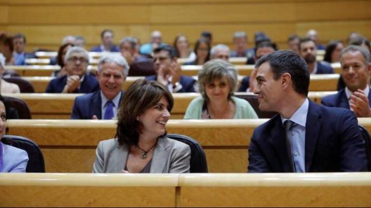 La ministra de Justicia, Dolores Delgado, se rie junto a Pedro Sánche, en el Senado.