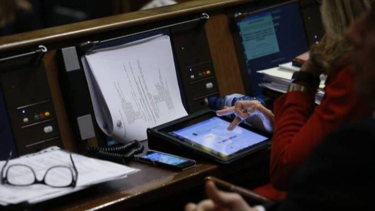Una diputada usa su ipad en el escaño.