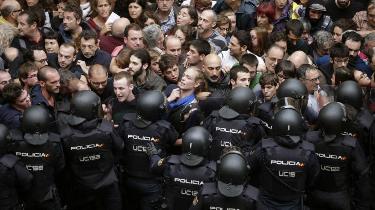 Agentes de la UIP, tratando de contener a la gente a la entrada de un colegio el 1 de octubre
