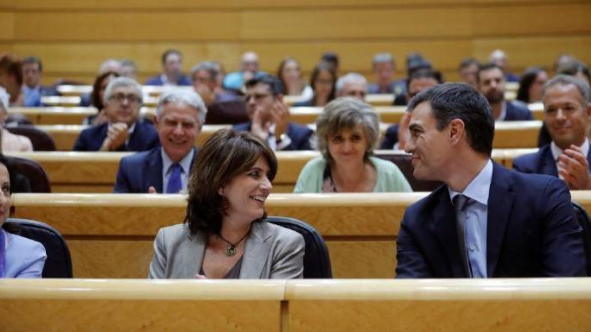La ministra Delgado sonríe en el Senado junto a Pedro de Sánchez.