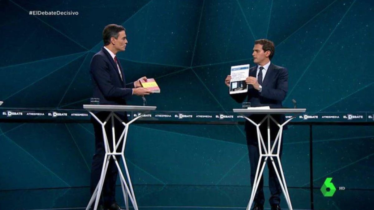 Rivera intercambiando la tess de Sánchez con el libro de Dragó sobre Abascal que le ofreció el presidente