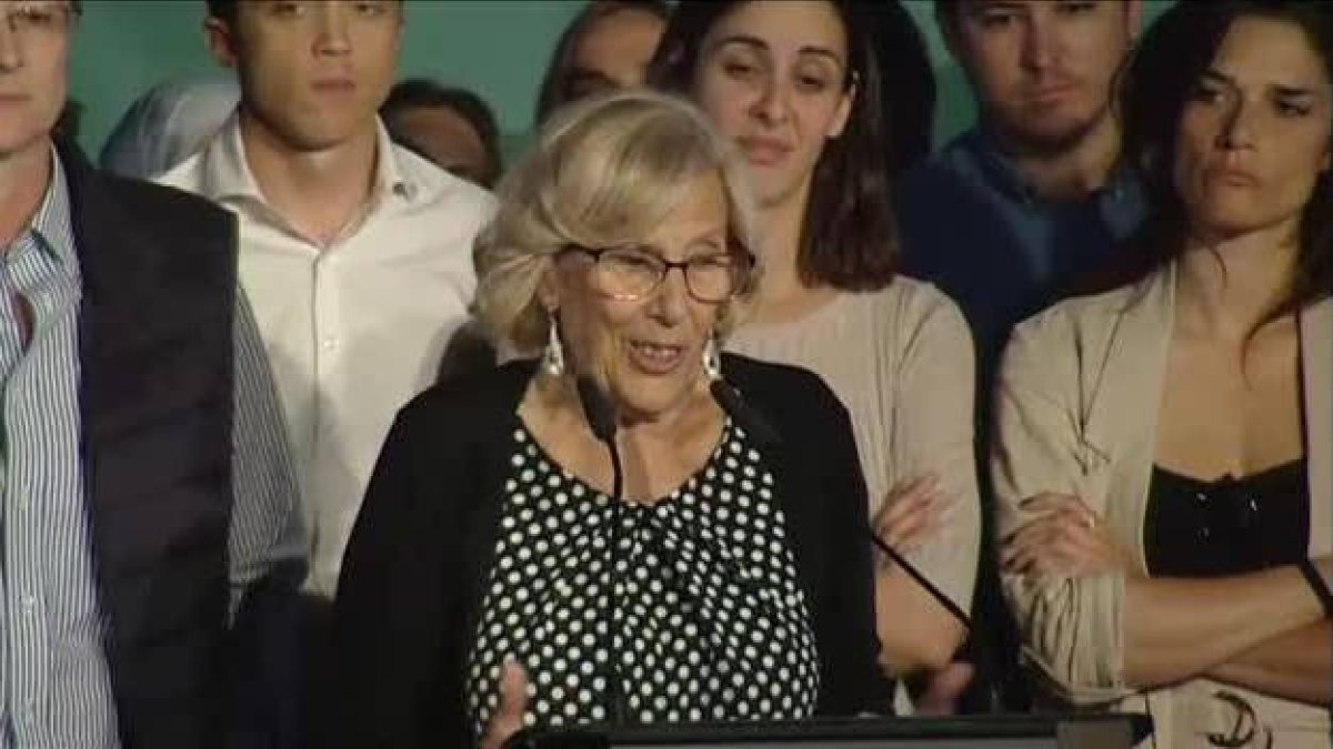 Rita Maestre detrás de Manuela Carmena, haciendo esfuerzos para no derrumbarse.