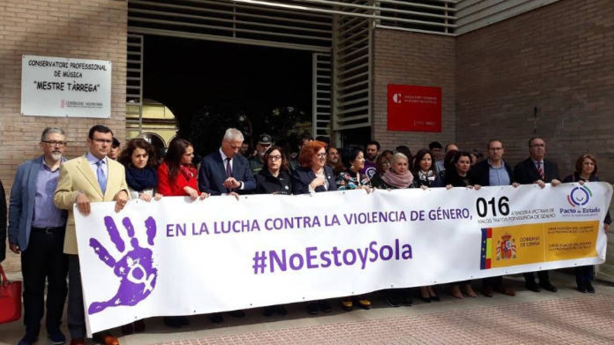 Minuto de silencio con la delegada del Gobierno en el centro de la pancarta