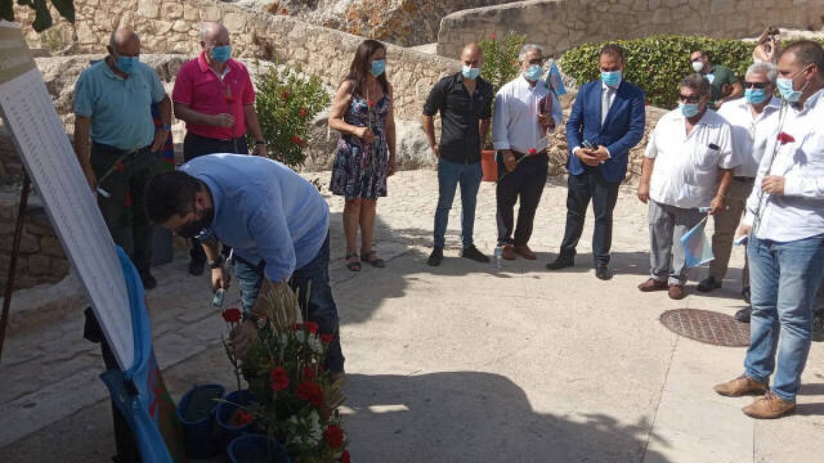 El concejal de Vox, Mario Ortolá, depositando el clavel en homenaje a las víctimas ante la mirada del resto de los portavoces