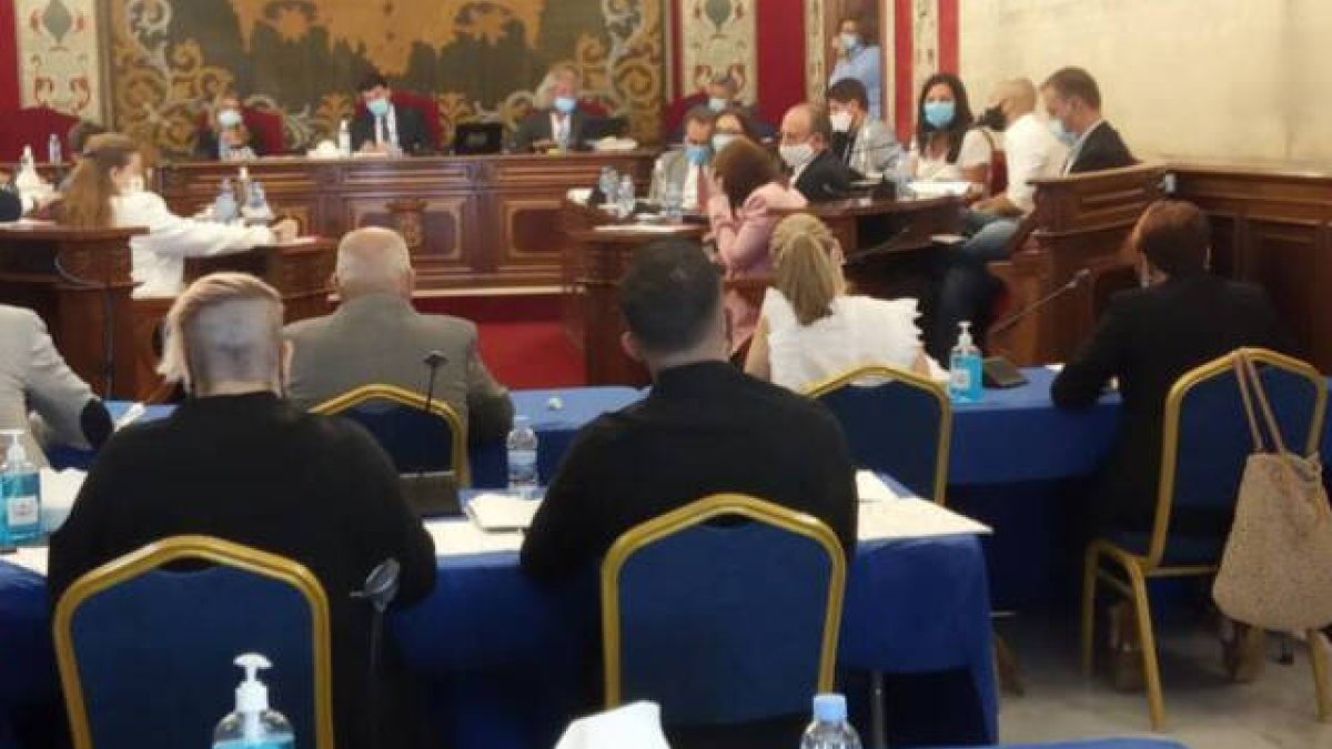 La concejal de Podemos (izquierda) ha comenzado el pleno en tirantes y después se ha puesto una chaqueta