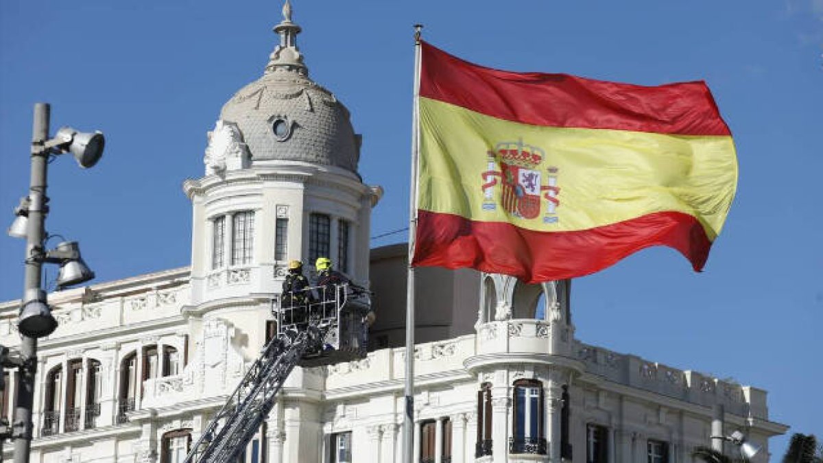 Bandera de españa en la Plaza del Mar, al fondo se ve la Casa Carbonell