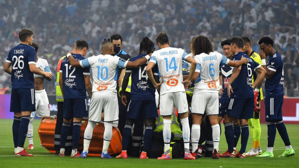Los jugadores de ambos equipos protegen la imagen de Samuel Kalu