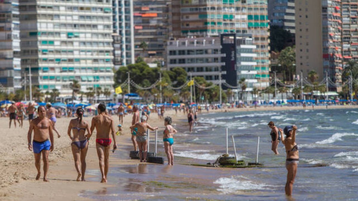 Turistas por la playa de Levante de Benidorm