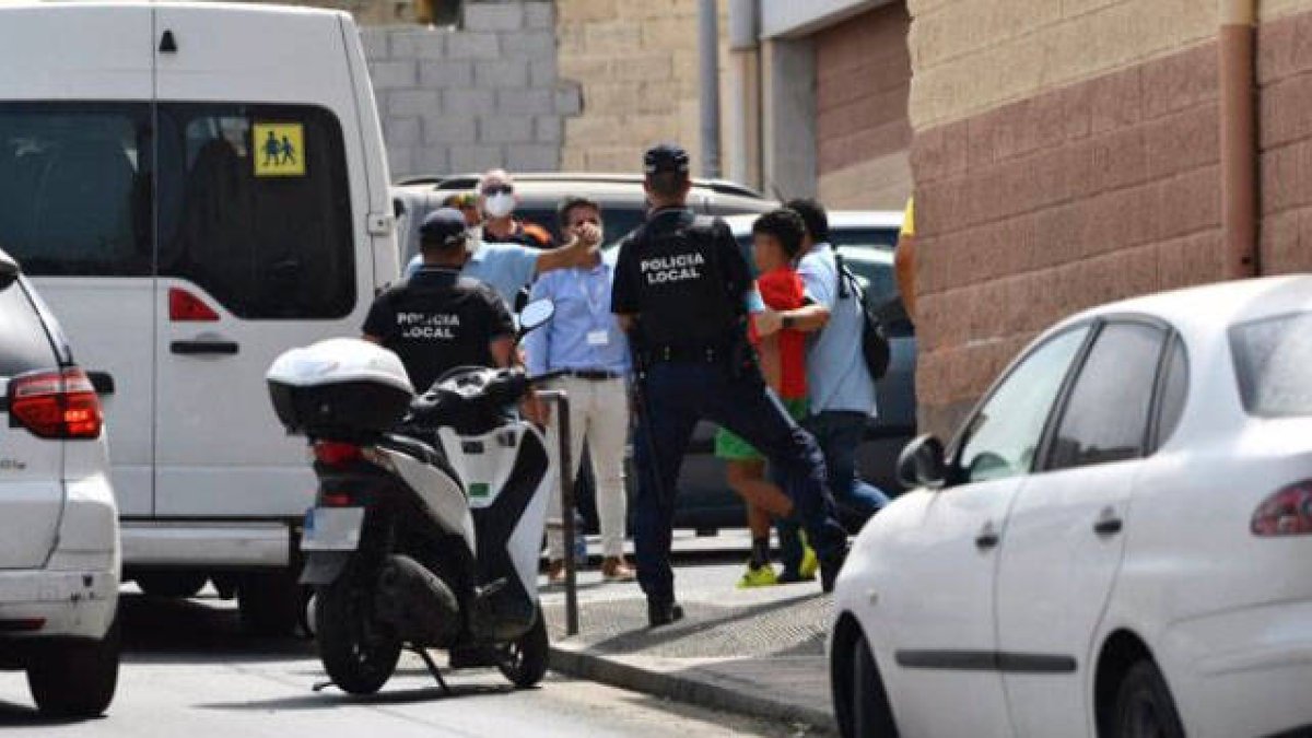 Varios agentes acompañan a menores a una furgoneta.