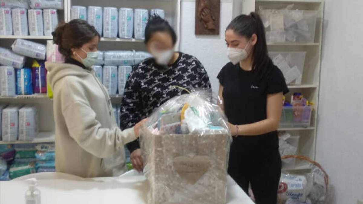 Dos voluntarias de Pro Vida Valencia con una mujer recibiendo ayuda