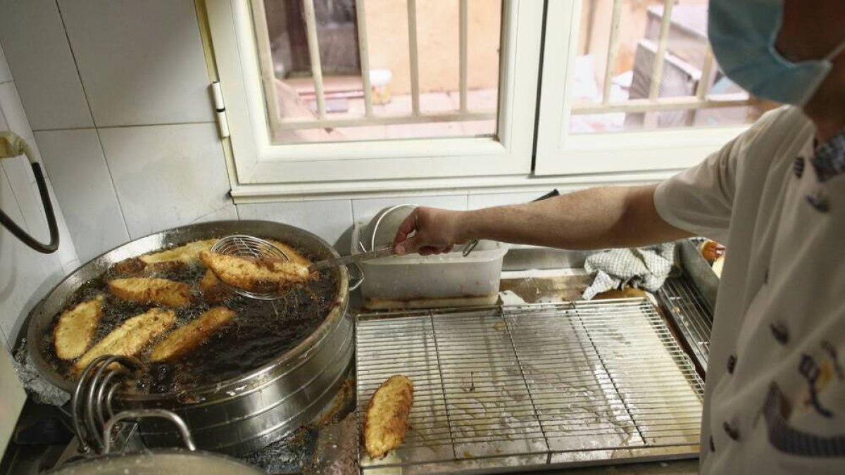 Un trabajador elabora torrijas en la Pastelería El Riojano (C/Mayor, 10), en Madrid