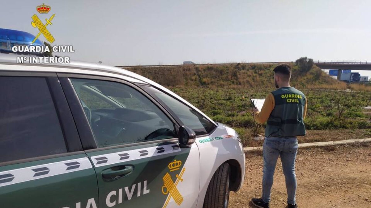 Agente de la Guardia Civil junto a su vehículo - OPC