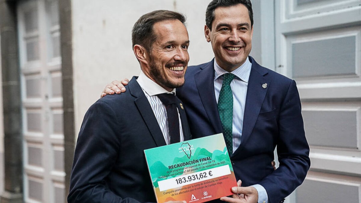El presidente andaluz, Juanma Moreno, le entrega al presidente del Cabildo de La Palma, Mariano Hernández Zapata, el cheque con la recaudación para los damnificados por el volcán.