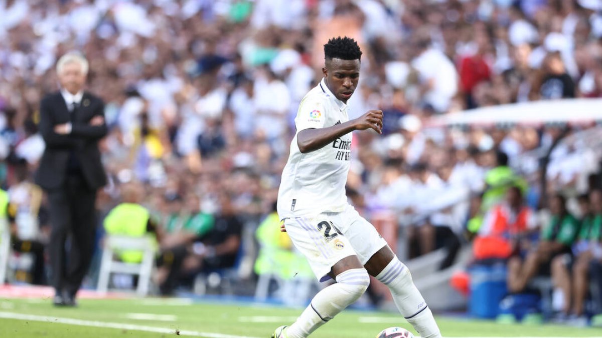 Vinicius controla un balón ante la antena mirada de Ancelotti.