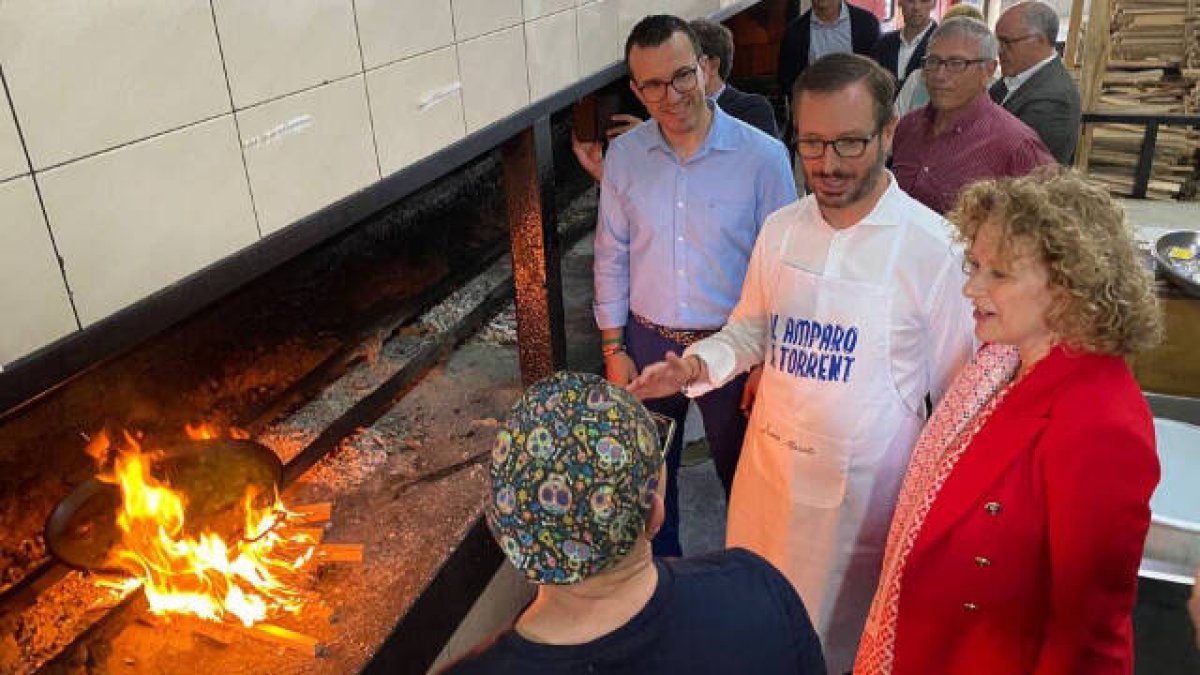 Javier Maroto, Vicent Mompó y Amparo Folgado ante una paella a leña
