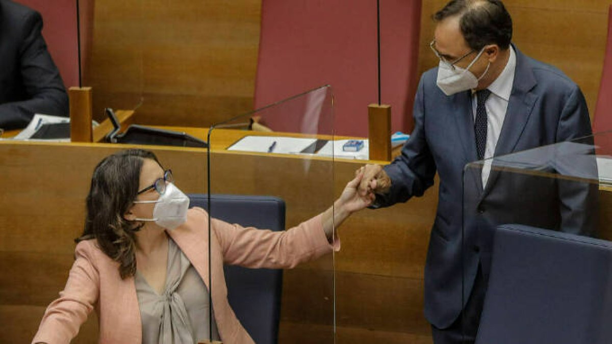 La vicepresidenta de la Comunidad Valenciana, Mónica Oltra, y el conseller de Hacienda, Vicent Soler, conversan durante un pleno de las Cortes valencianas