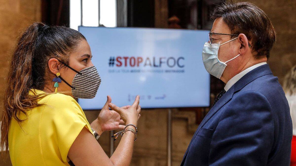 Mireia Mollà y Ximo Puig con un cartel de