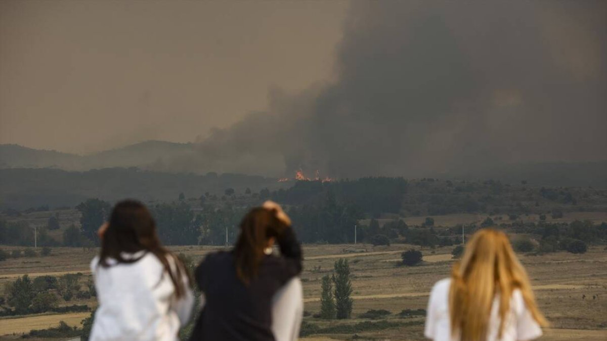 Tres personas viendo el humo del incendio de Bejís.