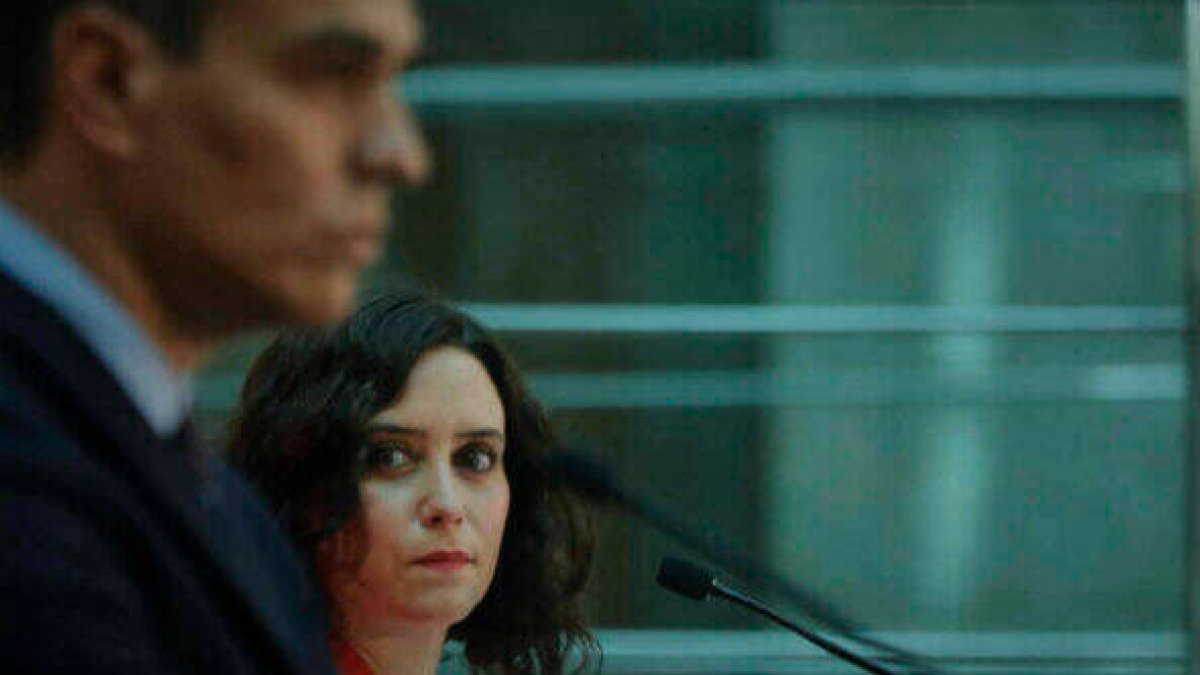 Isabel Díaz Ayuso mira a Pedro Sánchez, mientras este se dirige a los medios.