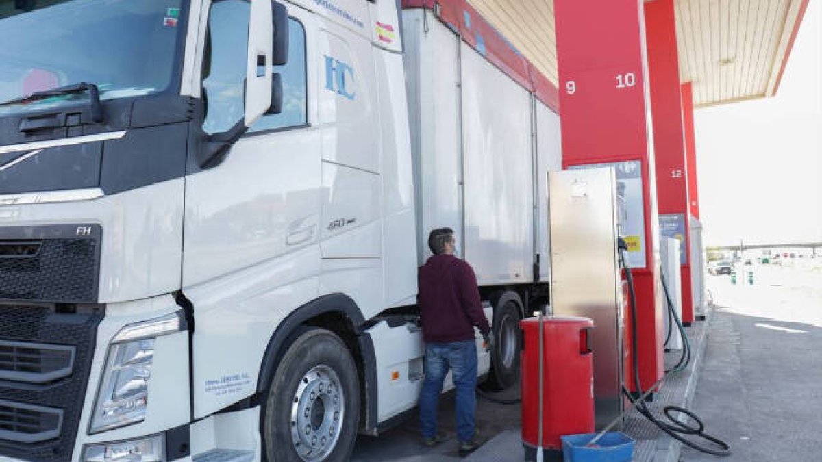 Foto de archivo: Una persona repostando su camión en una gasolinera.