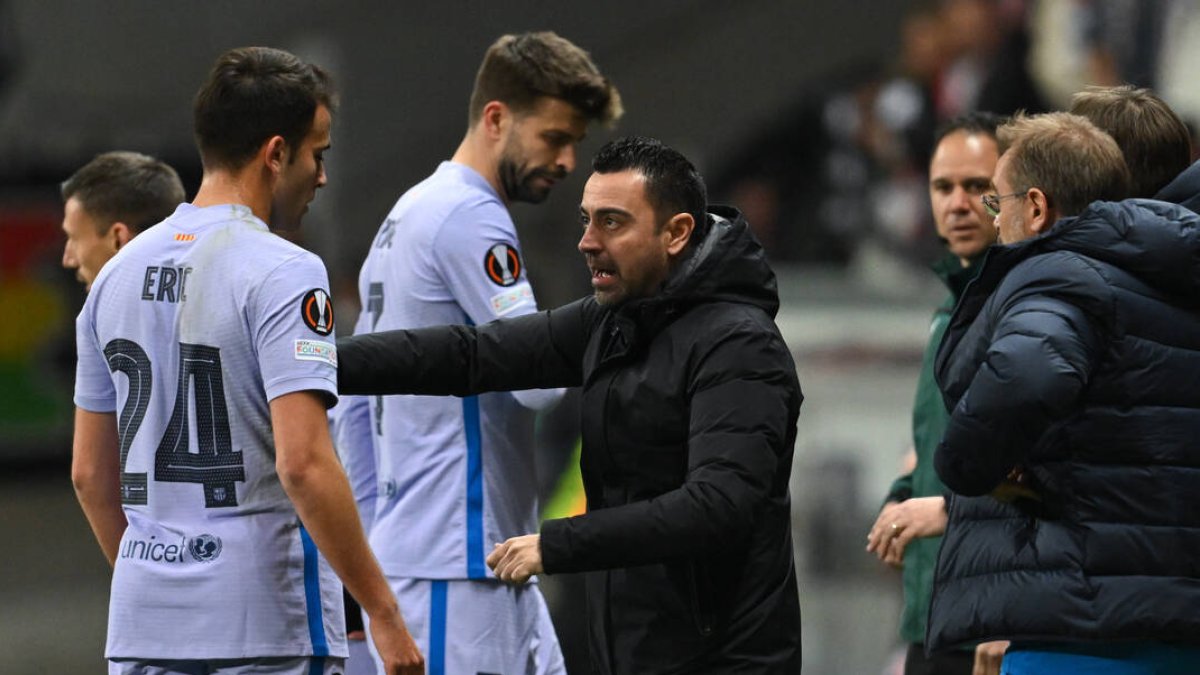 Xavi dando instrucciones con Piqué de fondo.