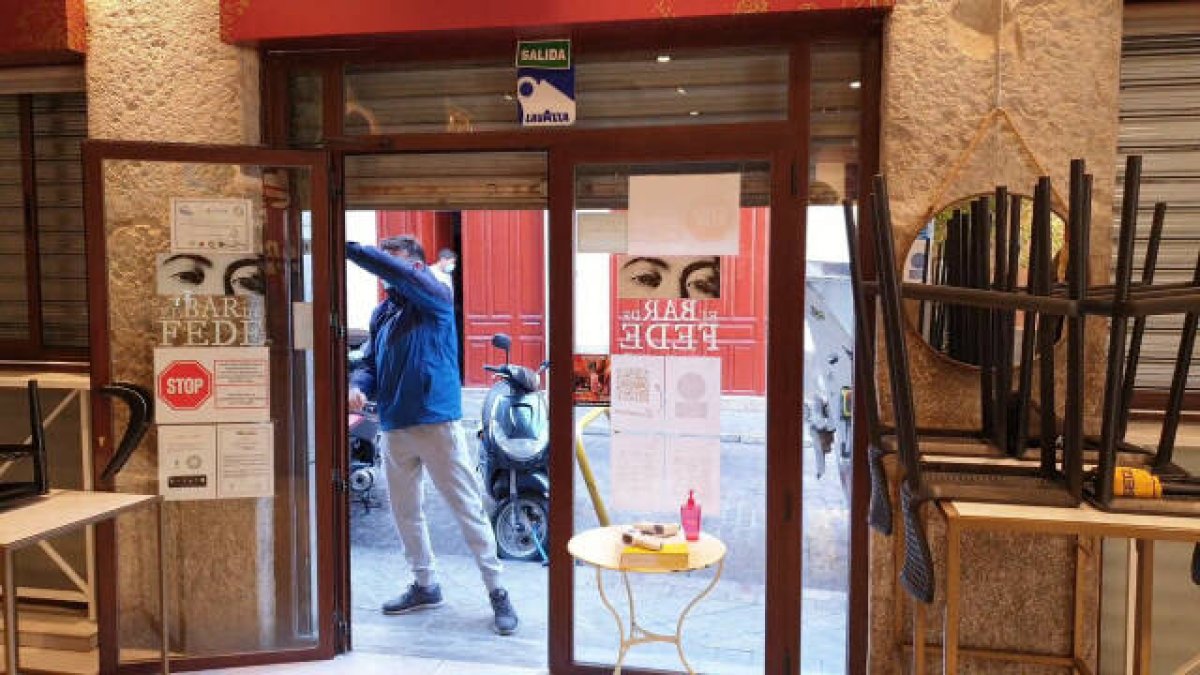 Un hombre abre su negocio en una imagen de archivo