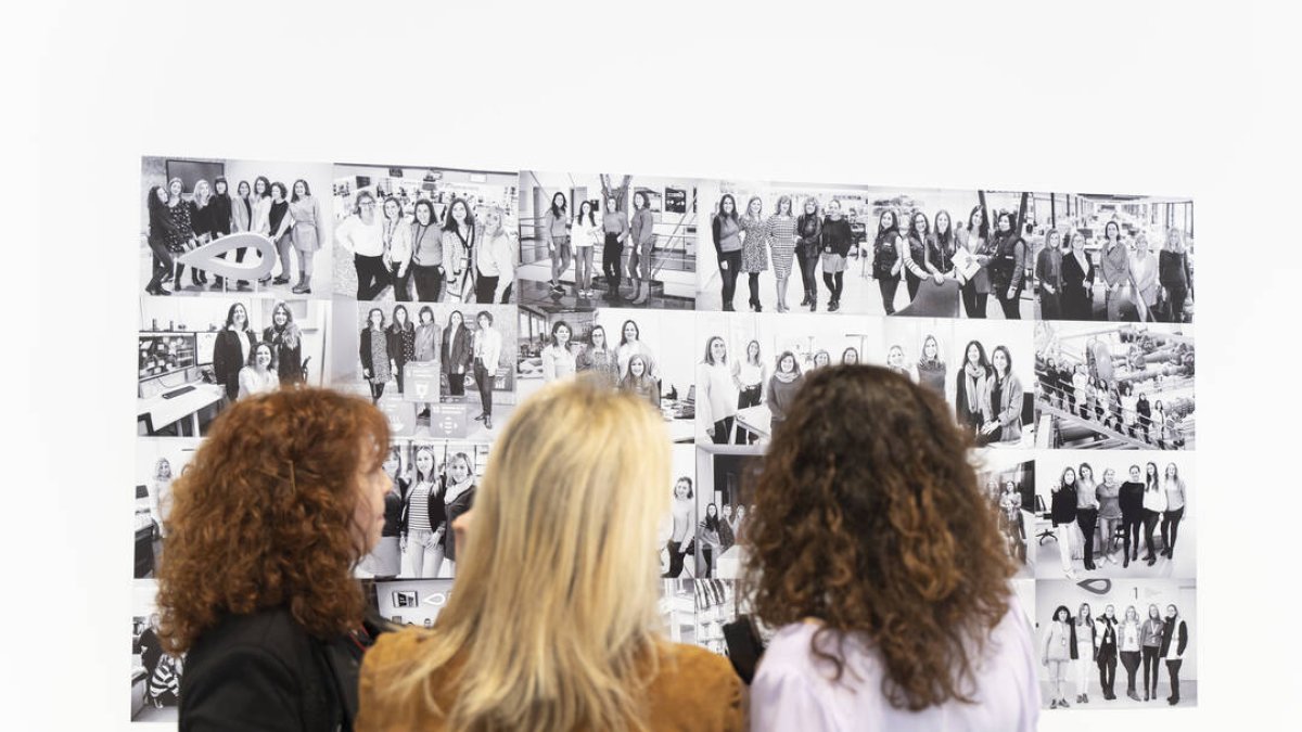 Tres mujeres observan algunas de las fotografías de la segunda edición de la exposición fotográfica ‘Las mujeres del agua’, en la sede de EMIVASA - EUROPA PRESS