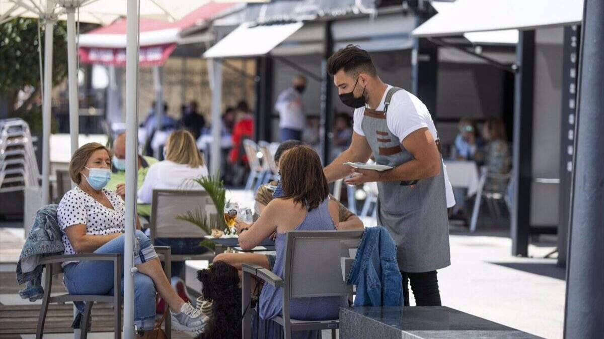 Varias personas en una terraza del paseo marítimo de la playa de Sanxenxo, en Pontevedra (Galicia)