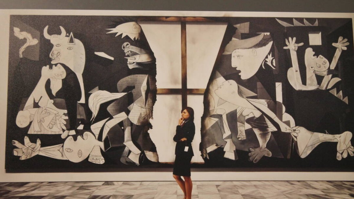 Una mujer enfrente de una de las piezas que conforman la exposición ‘Picasso. El viaje del Guernica’, en los Jardines del Torreón