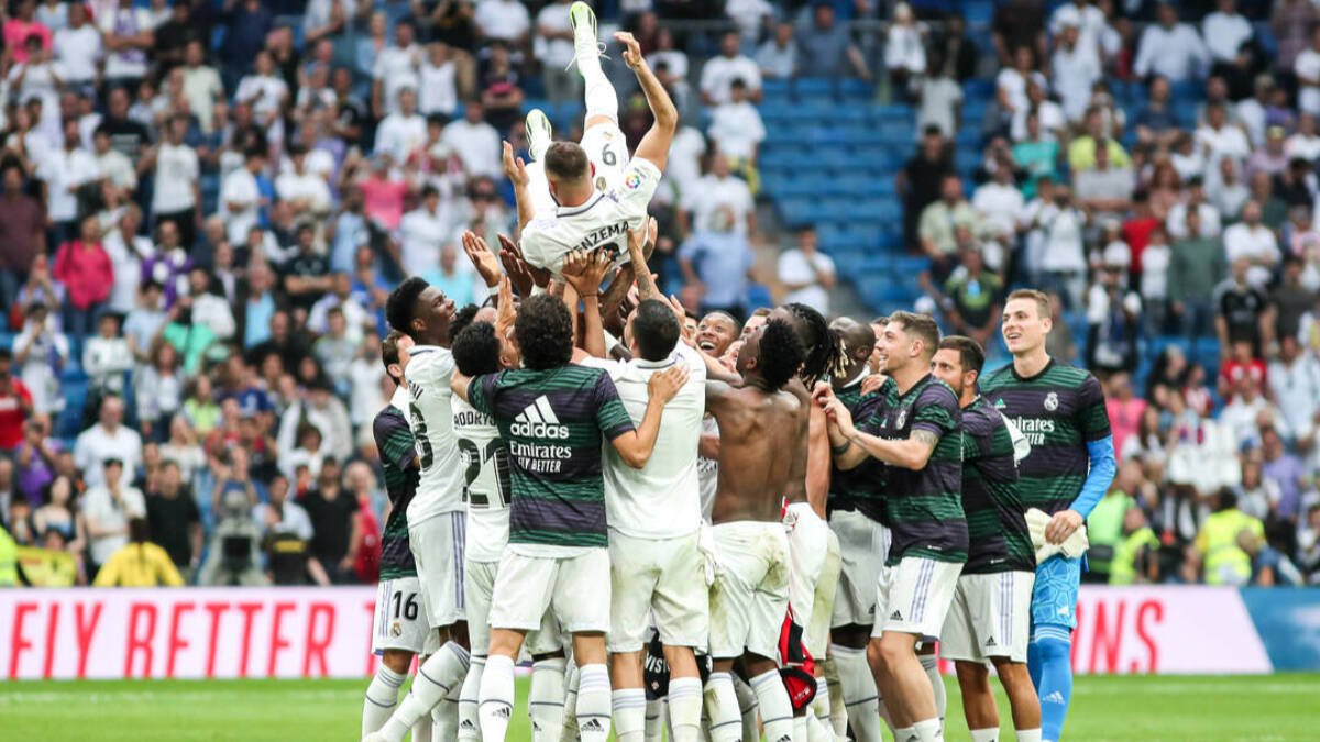 Los jugadores del Real Madrid mantean a Karim Benzema.