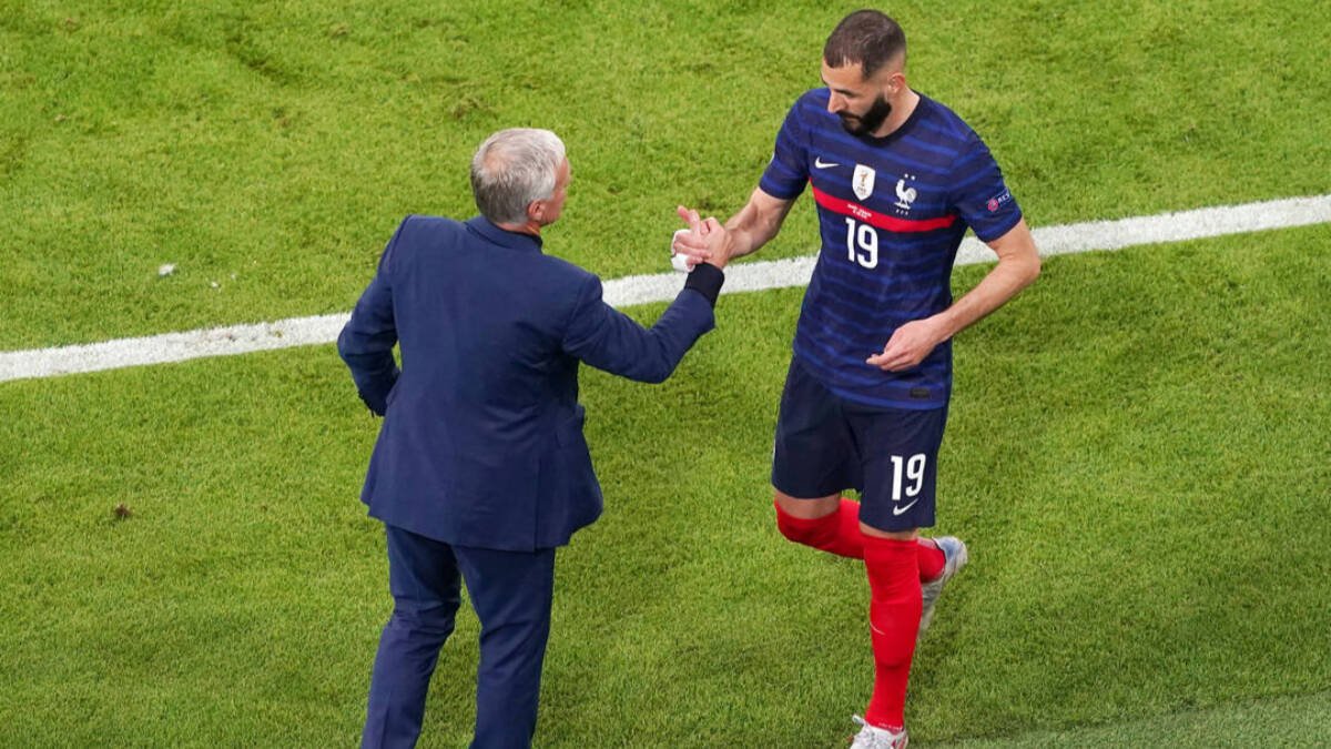 Karim Benzema saluda a Deschamps en un partido.